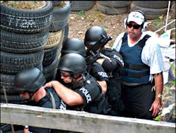 Author (at rear of stick) prepares to run SWAT operators through live fire drill at shoothouse. Live fire drills can and should be run with patrol officers as well. Author (at rear of stick) prepares to run SWAT operators through live fire drill at shoothouse. Live fire drills can and should be run with patrol officers as well.
