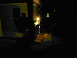 This image shows an individual hiding behind a 'wall of light' in front of a building. This image shows an individual hiding behind a 'wall of light' in front of a building.