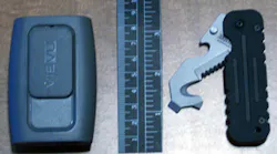 The VIEVU PVR-PRO2 shown with a ruler and a BLACKHAWK! Hawk Hook rescue tool. It's about the size of an old-style pager.