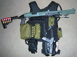 Shotgun and handgun &apos;system&apos; resting on the vest that holds the rest.