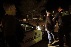 An ICE agent watches an Escondido gang investigator handcuff an illegal Mexican immigrant with a long rap-sheet. An ICE agent watches an Escondido gang investigator handcuff an illegal Mexican immigrant with a long rap-sheet.