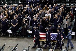 A casket bearing the body of slain corrections officer Jayme Biendl is carried into a memorial service.