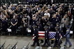 A casket bearing the body of slain corrections officer Jayme Biendl is carried into a memorial service.