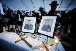 Framed photos of Buchanan County Deputy Sheriff's Eric Rasnake, Shane Charles, Neil Justus and William Stiltner, from left, are displayed on a table at a candlelight vigil. Framed photos of Buchanan County Deputy Sheriff's Eric Rasnake, Shane Charles, Neil Justus and William Stiltner, from left, are displayed on a table at a candlelight vigil.