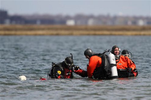 Suffolk County dive team police officers search for possible victims of a suspected serial killer on April 14.