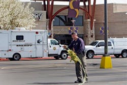ATF agent Doug Lambert rolls up police crime scene tape at one of the entrances at Southwest Plaza Mall in Littleton, Colo. ATF agent Doug Lambert rolls up police crime scene tape at one of the entrances at Southwest Plaza Mall in Littleton, Colo.