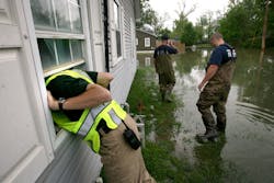 Poplar Bluff police detective Corey Mitchell, left, calls for an elderly woman, who was reported to be trapped in her home in the flood waters. Poplar Bluff police detective Corey Mitchell, left, calls for an elderly woman, who was reported to be trapped in her home in the flood waters.