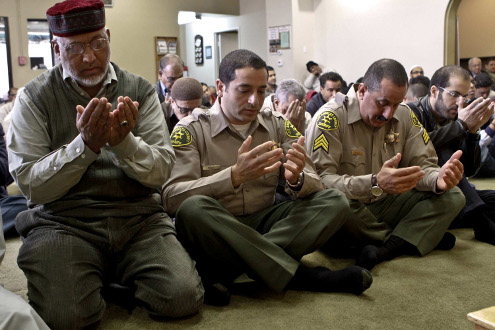 Syed Arif Rizvi, from left, president of the Islamic Center of the San Gabriel Valley in California, joins Deputy Sherif Morsi and Sgt. Mike Abdeen in prayers.