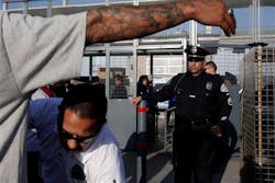 Los Angeles Officer Sean Karmody watches as a security guard searches a baseball fan before a game at Dodger Stadium on April 14. Los Angeles Officer Sean Karmody watches as a security guard searches a baseball fan before a game at Dodger Stadium on April 14.