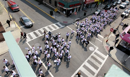 Laid off Paterson Police Department officers march down Church Street in Paterson, N.J. on Monday, April 18.