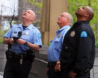 Police look up at a rope that is hanging out of a broken window on the second-floor of the St. Louis Justice Center in downtown St. Louis on Friday, April 22, 2011 in St. Louis.