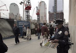 A New York City police officer looks at a copy of a newspaper featuring the image of Osama bin Laden, as she works adjacent to Ground Zero. A New York City police officer looks at a copy of a newspaper featuring the image of Osama bin Laden, as she works adjacent to Ground Zero.