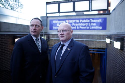 SEPTA Officer Michael Sylvester and FBI Agent Joe Metzinger stand at a subway entrance in Philadelphia.