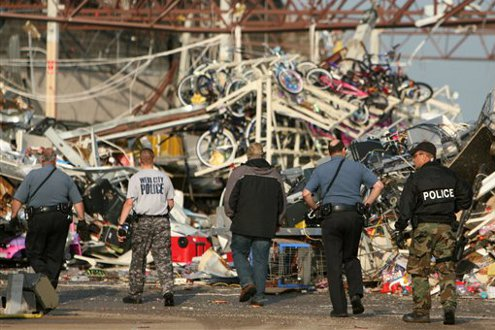 Police officers walk in to the back of a destroyed Wal-Mart store in Joplin, Mo.