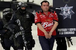 Gilberto Barragan Balderas, right, is escorted by police officers as he is presented to the media.
