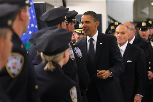 President Barack Obama, accompanied by Police Commissioner Raymond Kelly, and others, meets with officers at the First Precinct.