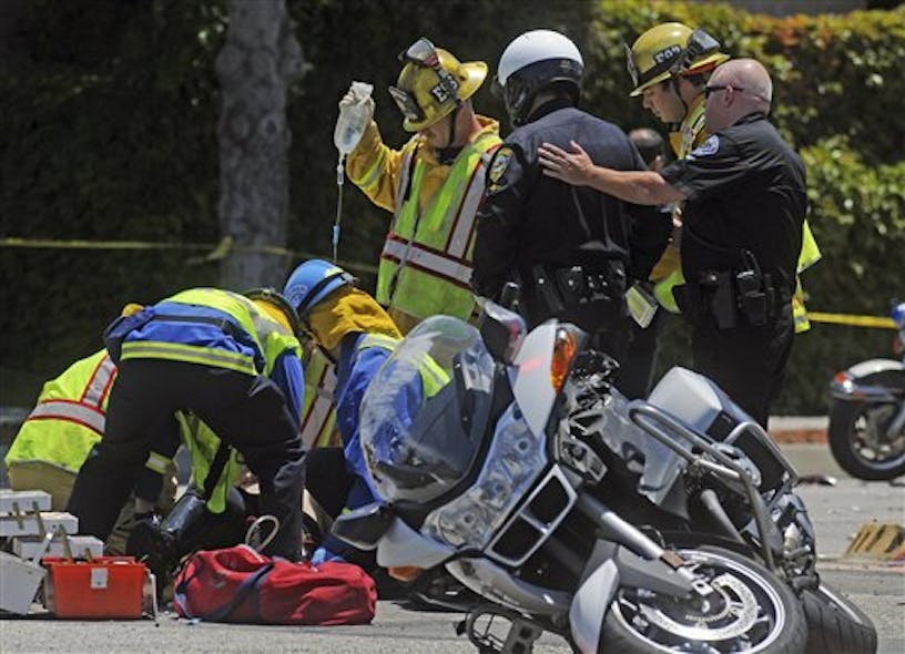 Emergency crews work on an El Segundo police officer injured in a traffic accident.