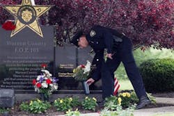 Kettering Officer Brian Hawley drops off some flower on the FOP Warren County memorial.