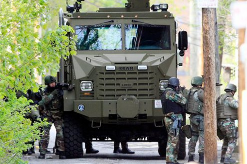 The state police SWAT team has guns drawn during a police standoff with an armed man.