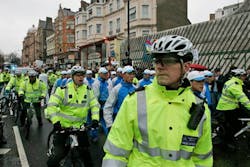 British police officers escort an Olympic torch bearer, as she runs in central London in 2008. British police officers escort an Olympic torch bearer, as she runs in central London in 2008.
