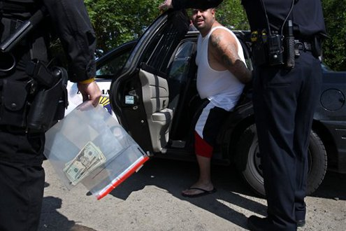 Gonzalo Esquivel, a leader in the Nuestra Familia, center, is placed in a Los Banos Police cruiser.