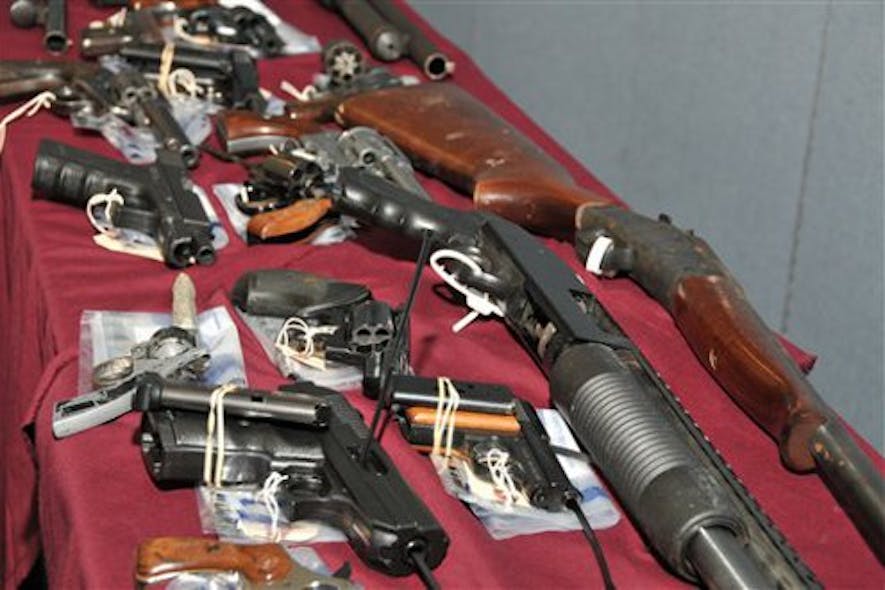A selection of guns lie on a table that are part of a group of 354 guns that were surrendered June 4.