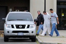 David Laffer is escorted out of Suffolk County Police Headquarters. David Laffer is escorted out of Suffolk County Police Headquarters.