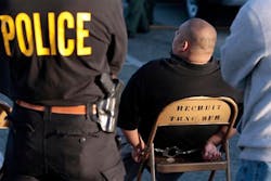 Law enforcement processes a suspected member of a gang following an early-morning raid. Law enforcement processes a suspected member of a gang following an early-morning raid.