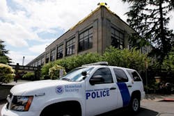 A police vehicle is parked outside a federal building that houses the Seattle Military Processing Center. A police vehicle is parked outside a federal building that houses the Seattle Military Processing Center.