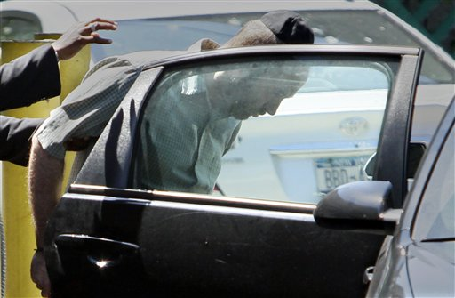 Detectives walk Levi Aron in a police car at Brooklyn's 67th precinct on Thursday.