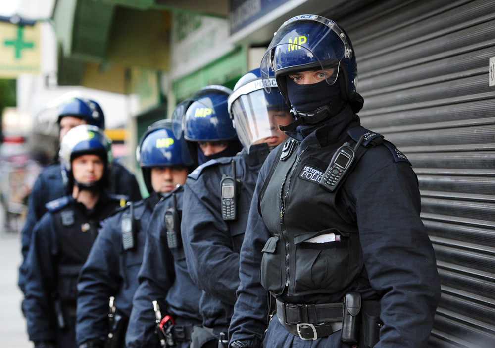 Metropolitan Police officers prepare to carry out a raid on a property on the Churchill Gardens estate.