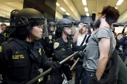 BART police officers push back a protester at the Civic Center station in San Francisco. BART police officers push back a protester at the Civic Center station in San Francisco.