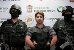 Mexico state policemen escort Oscar Garcia, 36, during a presentation to the press in Toluca. Mexico state policemen escort Oscar Garcia, 36, during a presentation to the press in Toluca.