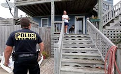 Nags Head Officer Edward Mann speaks with resident Debbie Hickey about Hurricane Irene. Nags Head Officer Edward Mann speaks with resident Debbie Hickey about Hurricane Irene.