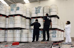 Police investigators look at drums of precursor chemicals for methamphetamine that were seized. Police investigators look at drums of precursor chemicals for methamphetamine that were seized.