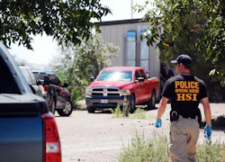 An unidentified DHS agent walks toward the cargo opening of New Deal Shooting Sports.