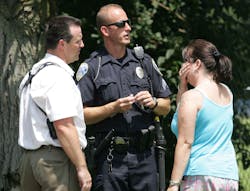 Members of the Akron Police Department talk to an unidentified woman claiming to be a relative at the scene of the shooting. Members of the Akron Police Department talk to an unidentified woman claiming to be a relative at the scene of the shooting.