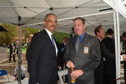 U.S. Attorney General Eric Holder talks with Dennis J. Hallion, executive director of National Troopers Coalition.