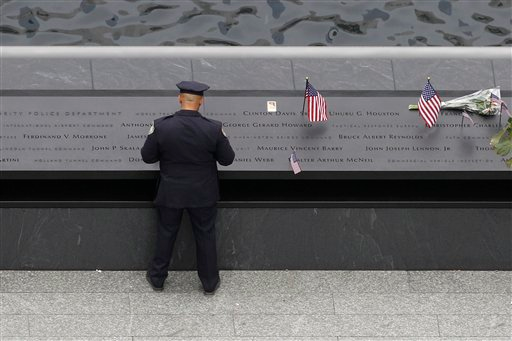 A police officer pauses by of one of the two waterfall pools after the ceremony.