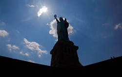 The Statue of Liberty is caught in an afternoon silhouette on Liberty Island in New York harbor. The Statue of Liberty is caught in an afternoon silhouette on Liberty Island in New York harbor.