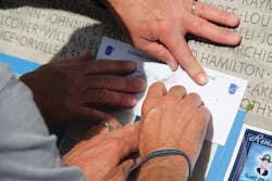 During 2011 National Police Week in Washington, D.C., the family of an officer killed in 2010 makes a pencil rubbing of his name etched in the memorial at Judiciary Square.