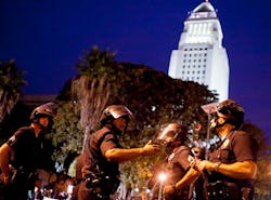 Los Angeles Police Offices stand guard across the street from the Occupy Los Angeles camp in front of Los Angeles City Hall, Monday, Nov. 27, 2011, in Los Angeles.