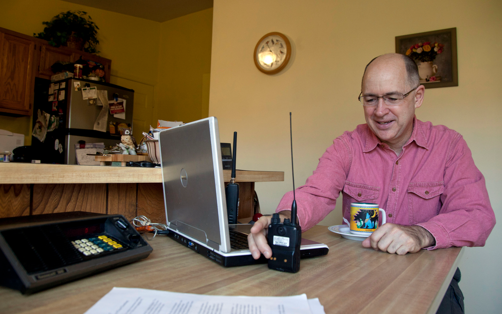 Scanner hobbyist Rick Hansen holds his scanner/Ham radio device at his home Saturday, Nov. 19, 2011, in Silver Spring, Md.