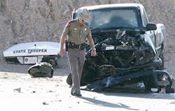 A Texas Department of Public Safety sergeant walks past the wreckage of a truck involved in an accident with a DPS patrol car Saturday March 24, 2012 in El Paso, Texas.