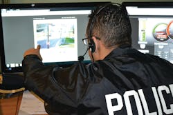 Policeofficelookingatvideoimag 10687928 Policeofficelookingatvideoimag 10687928