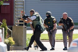 Police enter the Prudential Executive Group Real Estate office Friday, May 25, 2012, in Valpariso, Ind., where a gunman was holding an unknown number of hostages before shooting himself twice in the head. Police say the gunman held employees hostage inside the building for several hours before releasing the last two unharmed.