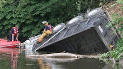 Akron Fire Department rescue workers check a dump truck that crashed in the Cuyahoga River behind the Valley Center Plaza on Akron Peninsula Road in Akron, Ohio on Thursday, July 5, 2012. Akron police and witnesses are calling driver Christopher Burgess, of Ravenna, a hero who sacrificed his life as he maneuvered his out-of-control vehicle down Portage Trail Extension, through a busy intersection and past a strip mall of pedestrians before crashing into the Cuyahoga River. After 90 minutes, rescuers were forced to use a crane to pull the industrial-sized vehicle from the water. Akron Fire Department rescue workers check a dump truck that crashed in the Cuyahoga River behind the Valley Center Plaza on Akron Peninsula Road in Akron, Ohio on Thursday, July 5, 2012. Akron police and witnesses are calling driver Christopher Burgess, of Ravenna, a hero who sacrificed his life as he maneuvered his out-of-control vehicle down Portage Trail Extension, through a busy intersection and past a strip mall of pedestrians before crashing into the Cuyahoga River. After 90 minutes, rescuers were forced to use a crane to pull the industrial-sized vehicle from the water.