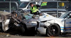 A Memphis police officer inspects the wreckage of a vehicle following a collision involving a fellow officer at the three-way intersection of Crump Blvd, Walnut St. and Georgia Ave. in Memphis, Tenn. Sunday, Aug. 26, 2012. Two people in the private car were killed, while two others were rushed to the Regional Medical Center at Memphis in extremely critical condition. The officer was also injured, although not as seriously. Witnesses said the officer was driving at high speed without his lights or siren on.