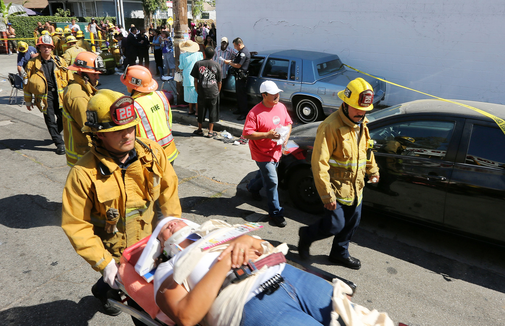 A Los Angeles City firefighter assists one of eight people injured when a car sped onto a sidewalk and plowed into a group of parents and children outside Main Street Elementary school, Wednesday Aug. 29, 2012 in Los Angeles. The crash occurred at 2:50 p.m., shortly after school had let out for the day, according to a statement from the Los Angeles Unified School District. Some of the people injured were children.
