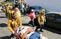 A Los Angeles City firefighter assists one of eight people injured when a car sped onto a sidewalk and plowed into a group of parents and children outside Main Street Elementary school, Wednesday Aug. 29, 2012 in Los Angeles. The crash occurred at 2:50 p.m., shortly after school had let out for the day, according to a statement from the Los Angeles Unified School District. Some of the people injured were children.
